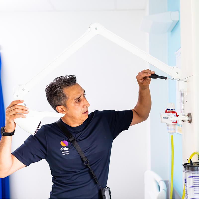 Mitie engineer fixing a lamp