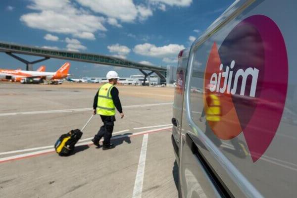 Mitie engineering near the runway at an airport, with Mitie van in foreground